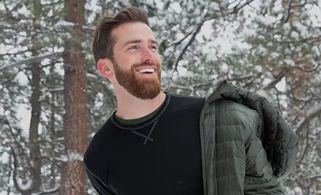 man in snow wearing black merino wool long sleeve